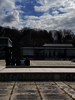 Personen auf dem PH Gelände sitzend auf dem Brunnen vor dem Hauptgebäude mit Blick auf die Mensa.