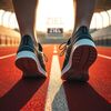 Sportschuhe auf einer Laufbahn auf dem Weg Richtung Ziel.