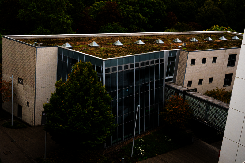 Das bIld zeigt Gebäude 7 der Pädagogischen Hochschule. Ein modern aussehendes Gebäude mit einer eingesetzten Glasfassade und einer Brücke zu einem anderen Gebäude. 