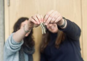 Menschen zeigen einen Wohnungsschlüssel